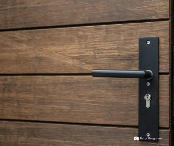 Close-up of a door handle on a modern facade with MOSO Bamboo X-treme wood cladding, highlighting its natural texture.